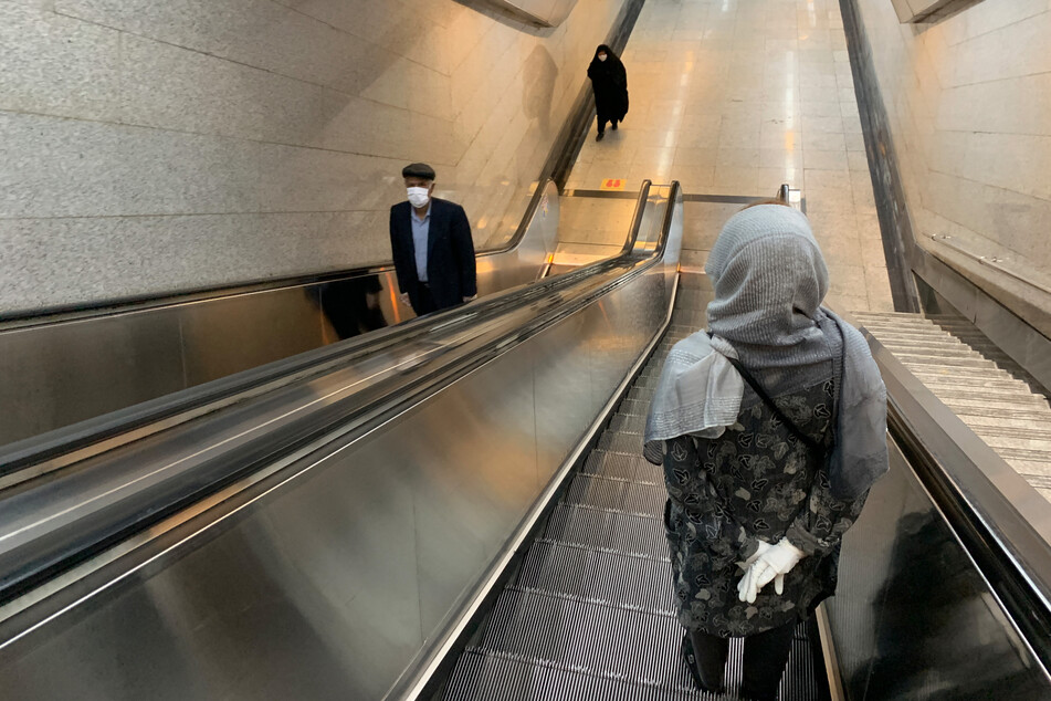 Menschen stehen auf der Rolltreppe der U-Bahn Station Tadschrisch.
