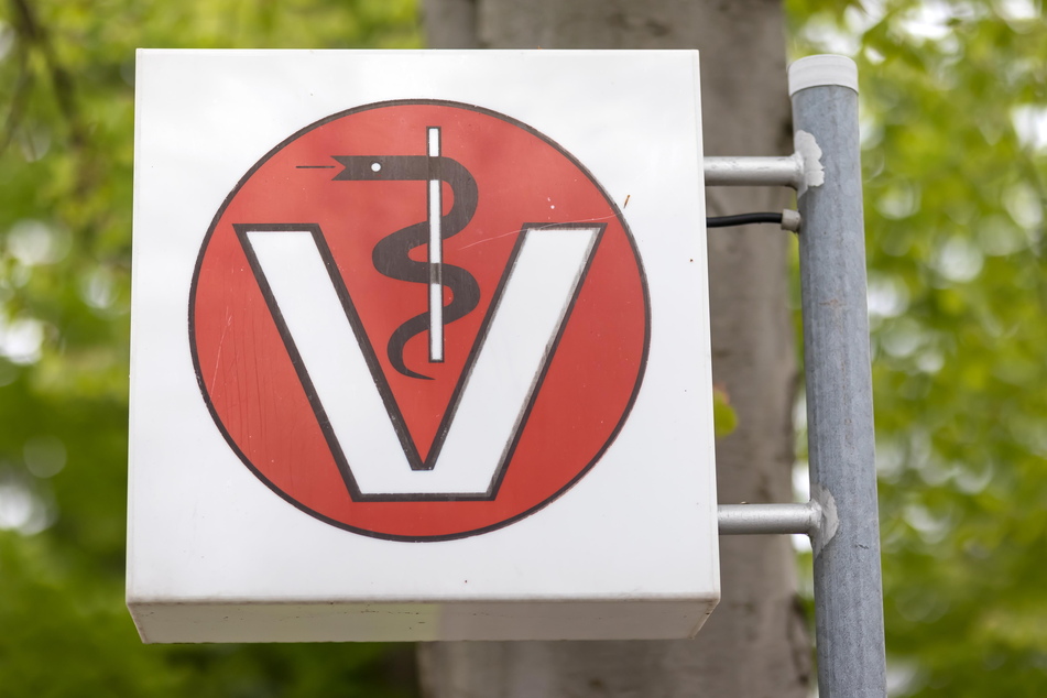 Tierärzte, für die das Symbol mit Schlangenstab und dem "V" für "Veterinär" steht, klagen über hohe Belastungen.