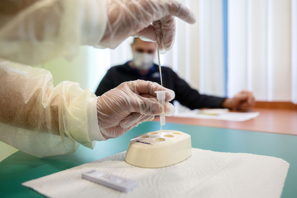 Eine Pharmazeutisch-Technische Assistentin führt in der Hitzemann-Apotheke am Feuerbach nach einer Probenentnahme einen Corona-Schnelltest durch.
