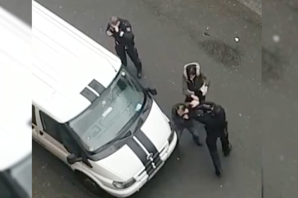 Der Polizist und der Mann schlagen aufeinander ein.