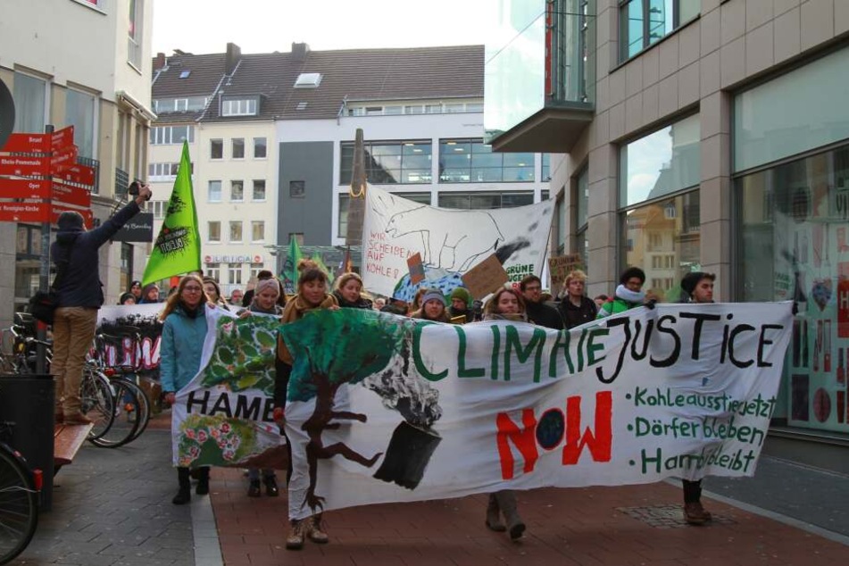 Auf einem Banner steht "Climate justice now".