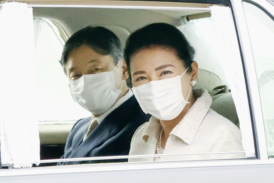 Kaiser Naruhito (60, l) von Japan und seine Frau Kaiserin Masako von Japan (56) tragen jeweils einen sehr schlichten Mund-Nase-Schutz während einer Fahrt zum Kaiserpalast.