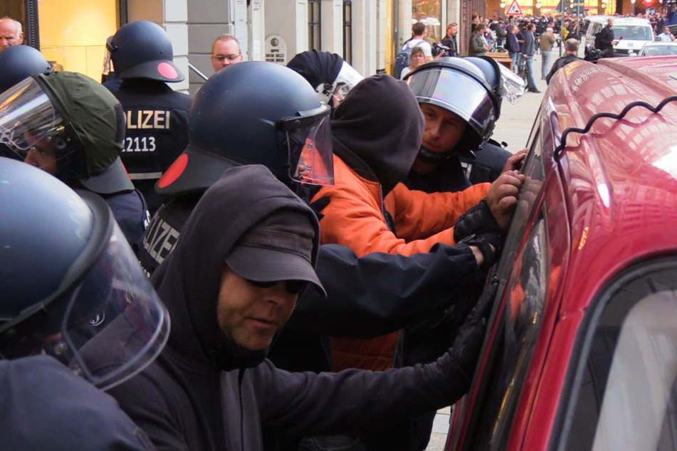 Demo-Teilnehmer werden von der Polizei kontrolliert.