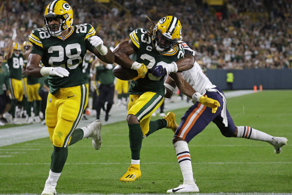 Green Bay Packers running back AJ Dillon (l.) blocks for running back Aaron Jones (c.) as he scores a touchdown against the Chicago Bears.