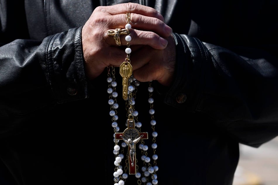 A parishioner of the Cathedral of the Immaculate Conception Catholic Church in Camden, New Jersey, holds rosary beads while taking part in a live Stations of the Cross on March 29, 2024.