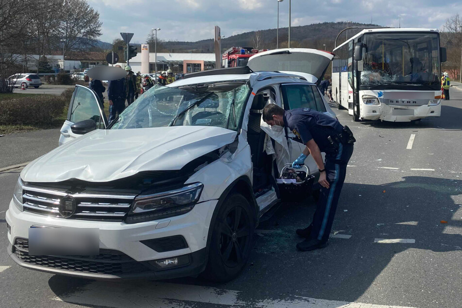 Ein Polizist sichert Spuren am demolierten Unfallwagen.