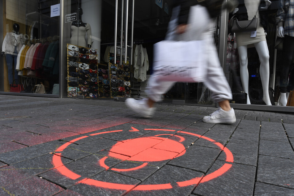 Ein Symbol weist auf die Maskenpflicht in der Kölner Innenstadt hin. Am Donnerstag (13 Uhr) berät der NRW-Landtag, wie die dritte Corona-Infektionswelle gebrochen werden könnte.
