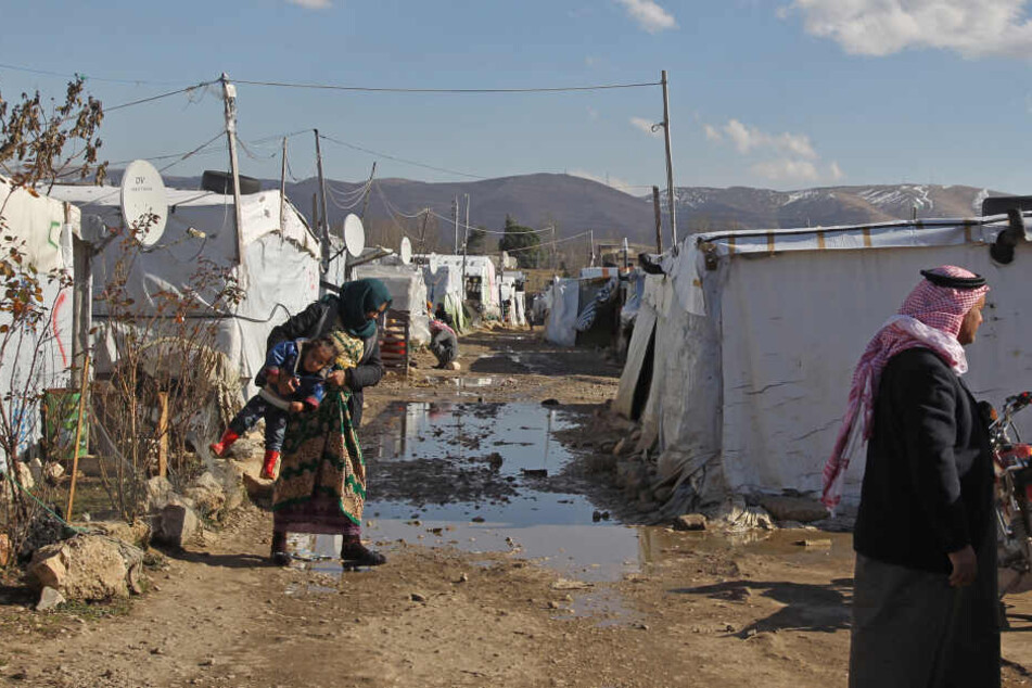 Syrische Flüchtlinge gehen durch ein Flüchtlingslager in der Bekaa-Ebene.