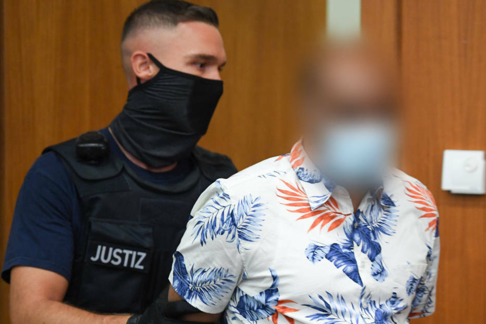 Ein Justizbeamter (l) führt einen 41-jährigen Angeklagten zum Prozessauftakt in den Gerichtssaal des Frankfurter Landgerichts.