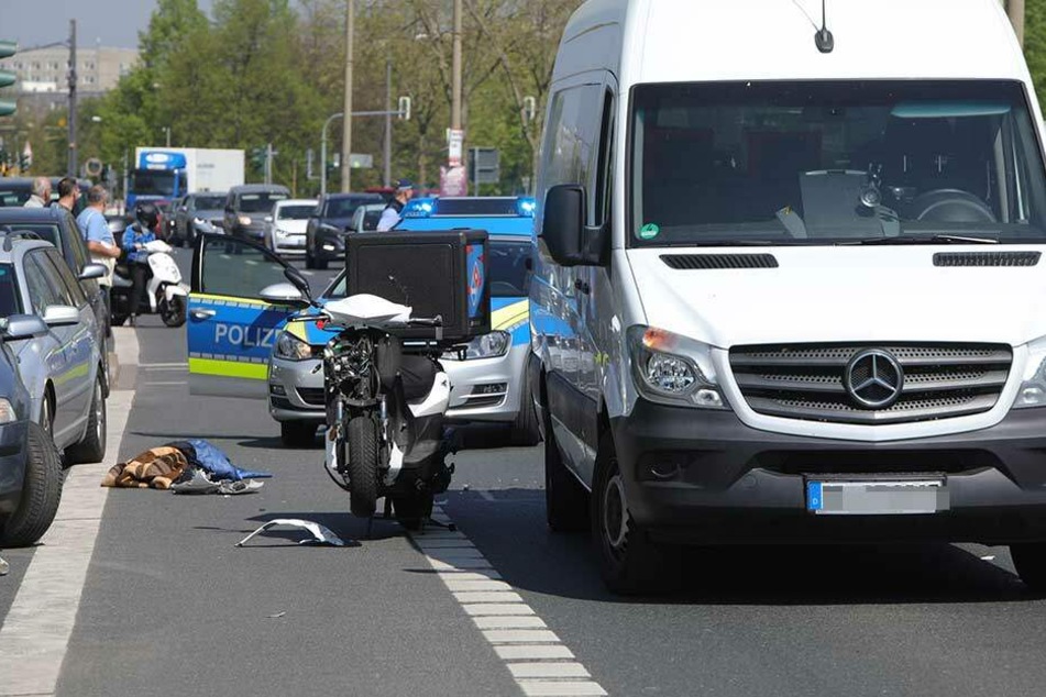 Der demolierte Roller des Pizza-Lieferdienstes steht neben dem weißen Transporter.