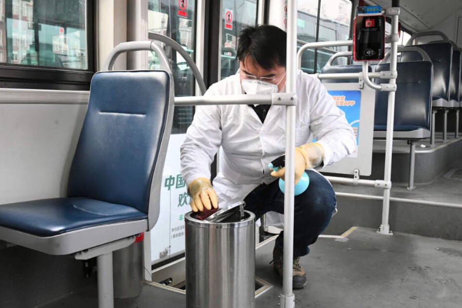 Ein Mitarbeiter des Verkehrsdienstes "Beijing Public Transport Corporation" führt in Peking Desinfektionsarbeiten in einem Bus am Busbahnhof durch.