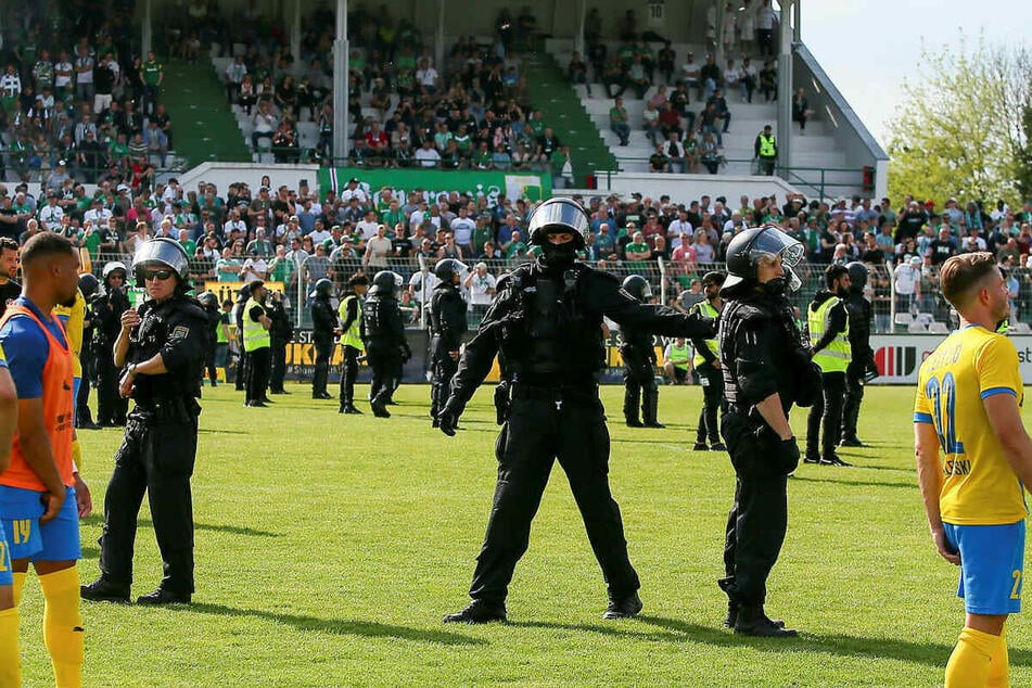 In voller Montur auf dem Rasen: Bereits während des Spiels musste die Polizei einschreiten und dieses vorübergehend unterbrechen, um für Ruhe zwischen den Fan-Blöcken zu sorgen.