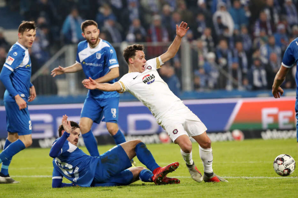 Dennis Erdmann (am Boden) hebt entschuldigend den Arm. Getroffen hatte er Clemens Fandrich im Strafraum dennoch.