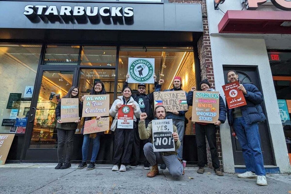 Starbucks workers in Farmingville, New York, hold up signs during the 2023 Red Cup Rebellion, including one calling for Palestinian freedom.