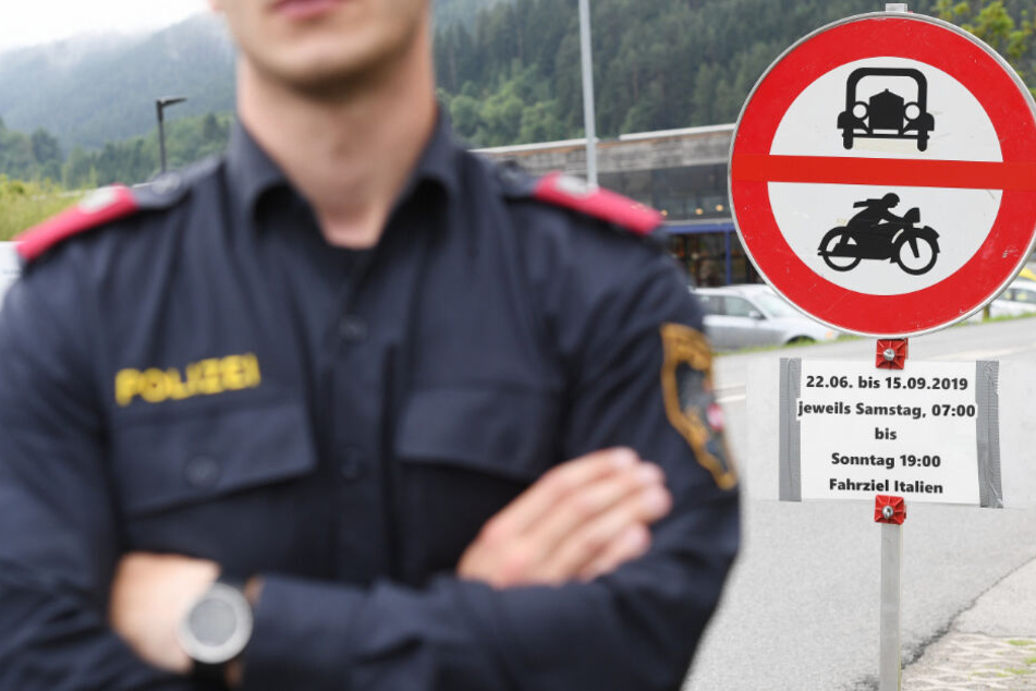 Ein Polizist steht vor einem Schild, das auf die Sperrung für den Verkehr mit Fahrziel Italien hinweist.