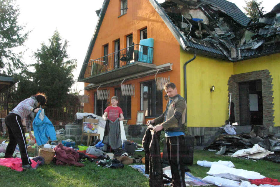 Aufräumen nach der Brandkatastrophe: Sergey (46), Natalie (43) und Sohn Philipp (13) lüften ihre verqualmte Kleidung.