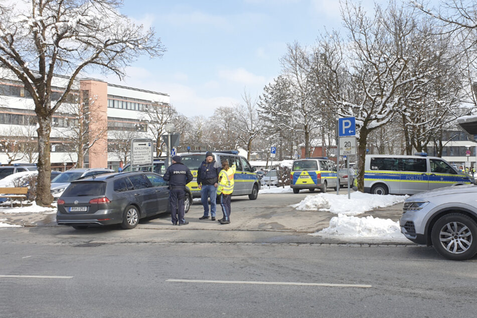 Mehrere Einsatzfahrzeuge der Polizei stehen vor der betroffenen Berufsschule in Traunstein.
