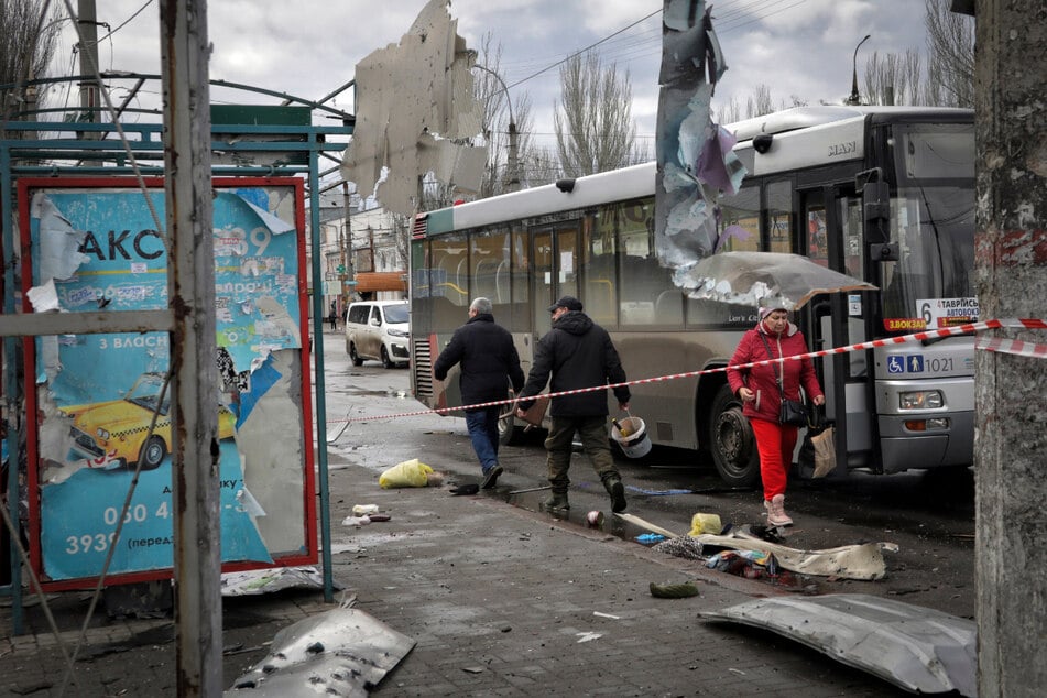 Anwohner gehen an einem Busbahnhof in Cherson entlang, der nach einem Beschuss durch Russland beschädigt wurde.