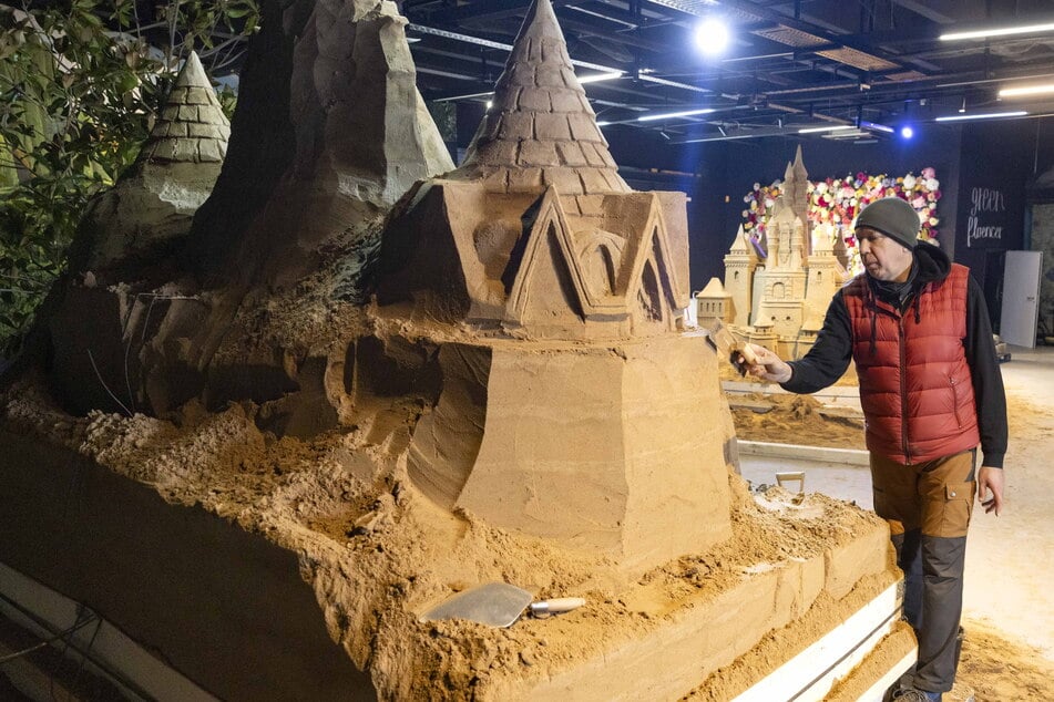 Künstler Jeroen van de Vlag (55) arbeitet an einer großen Fantasieburg aus Sand.