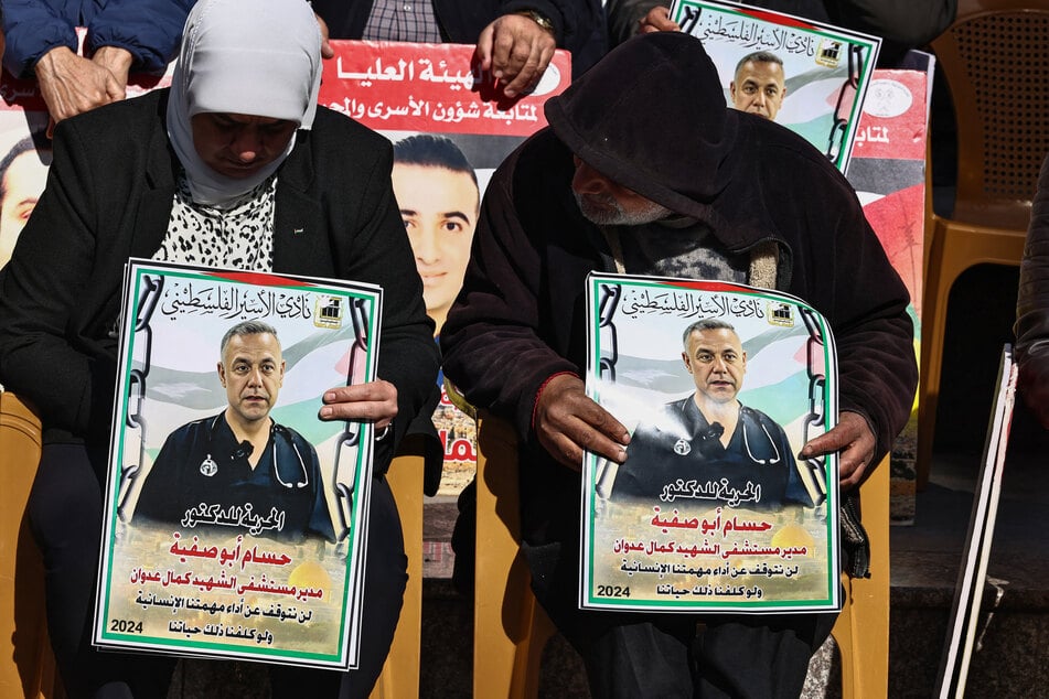 People hold signs with portraits of Palestinians currently detained by Israel, including Dr. Hussam Abu Safiya, during a protest in Ramallah in the occupied West Bank on January 14, 2025.