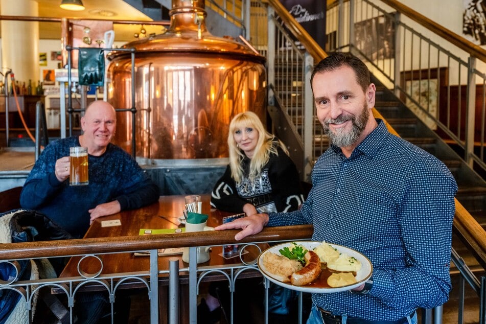 André Donath (59, r.) mit seinen Gästen Ralph Götze (66) und Natalija Götze (44). Auf dem Teller: die Angebots-Bratwurst.