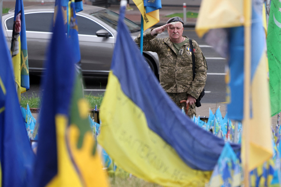 Officer of the 10th Mountain Assault Brigade and veteran of the Russian-Ukrainian war, Oleg Bozhenk pays his respects at a makeshift memorial for fallen Ukrainian soldiers at Independence Square in Kyiv.