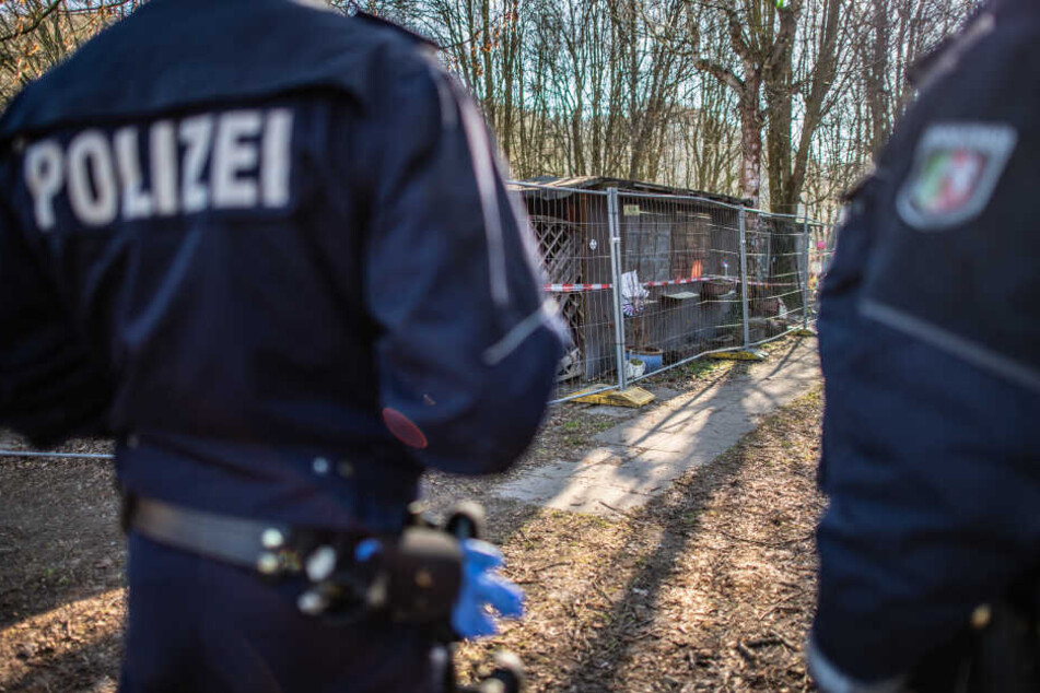 Zwei Beamte der Polizei bei Ermittlungen auf der Parzelle.