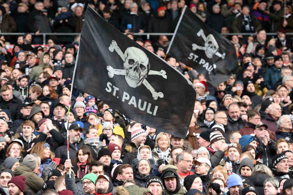 Hamburgs Fans schwenken St. Pauli-Fahnen im Stadion.