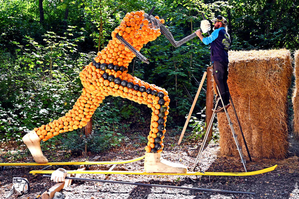 Holzgestalter Dirk Born (45) arbeitet an der über drei Meter hohen Figur des Biathleten.