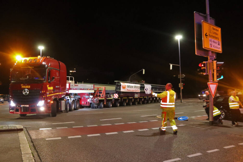 Ein Schwertransporter mit einem Stahlbauteil für eine neue Brücke ist in der Nacht unterwegs.