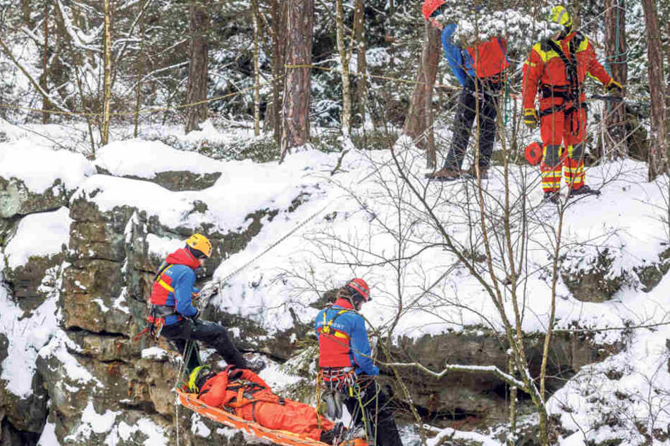 Bestimmt keine Weicheier! Mindestens vier Leute der Bergwacht Dresden seilen einen Verletzten in einer Korbtrage ab - und zwar trotz klirrender Kälte!