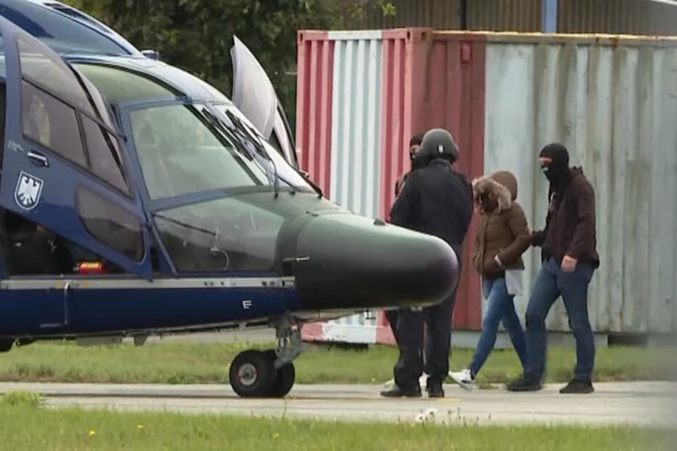 Die deutsche und tunesische Staatsangehörige Omaima A. wird von vermummten Polizisten zu einem Hubschrauber der Bundespolizei geführt.
