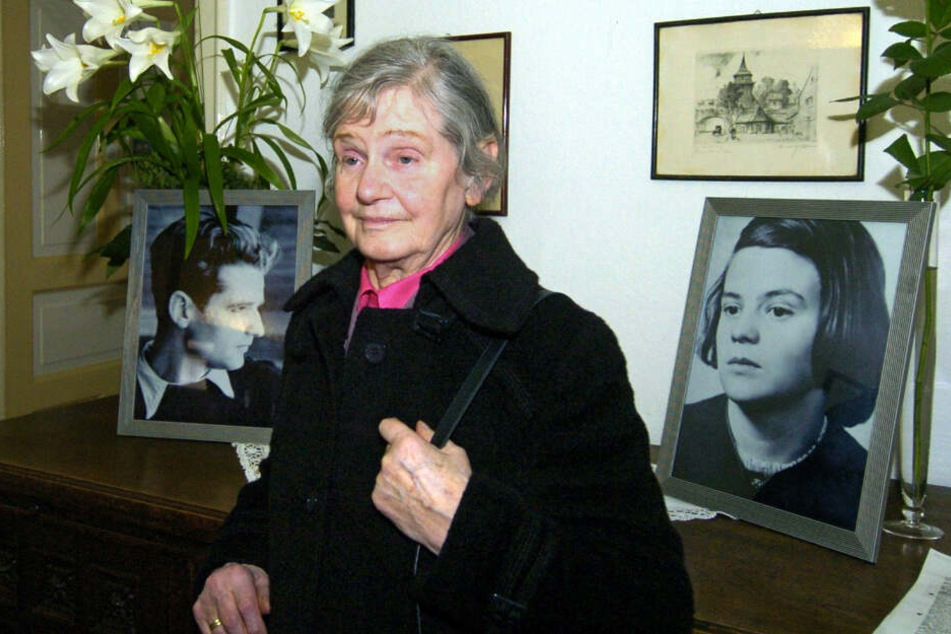 Elisabeth Hartnagel-Scholl steht in der früheren Wohnung ihrer Eltern in Ulm zwischen Fotos ihrer Geschwister Hans und Sophie Scholl.