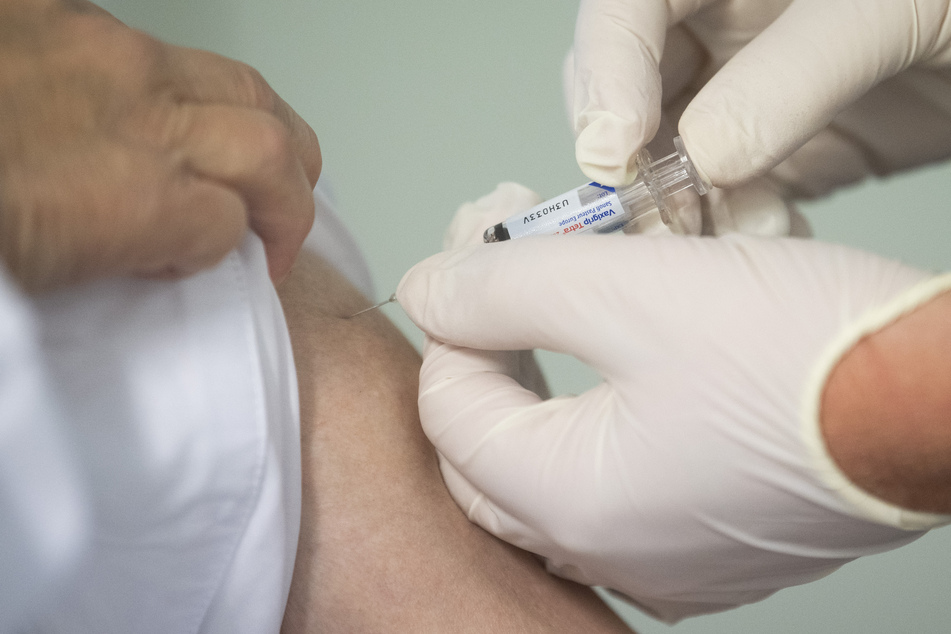 Ein Mann lässt sich gegen Grippe impfen.