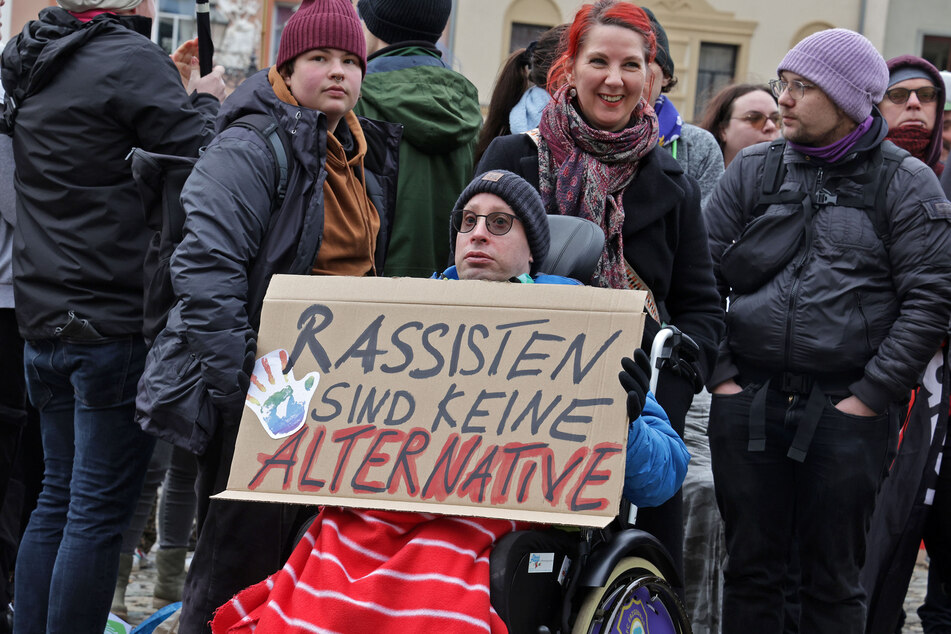Ein Teilnehmer hält ein Plakat in der Hand: "Rassisten sind keine Alternative".