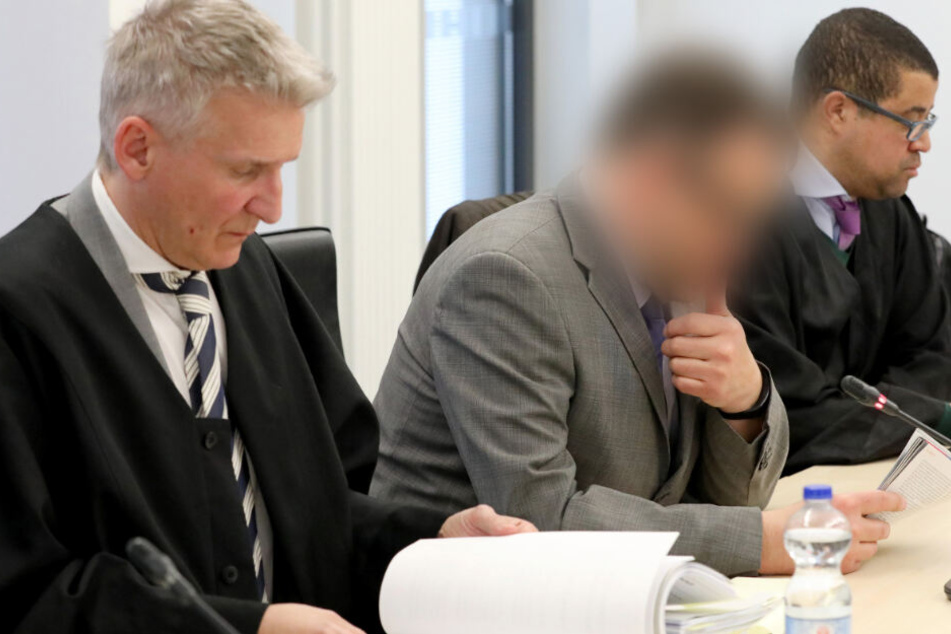 Der Angeklagte Neurochirurg sitzt zwischen seinen Anwälten Temba Hoch (rechts) und Wolf Klink. (Archivbild)
