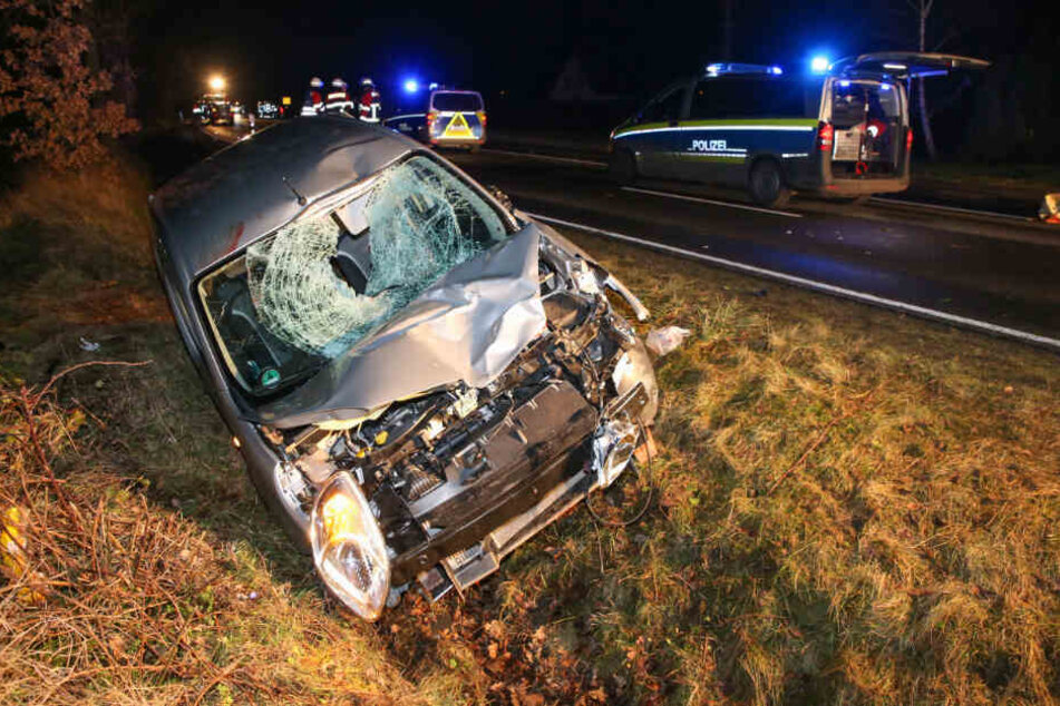 Nach dem Zusammenstoß liegt ein beschädigtes Auto im Straßengraben.