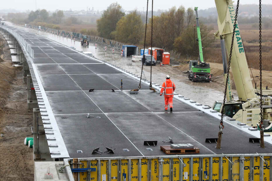 An der Behelfsbrücke für die abgesackte A20 wird das letzte Bauteil verlegt.