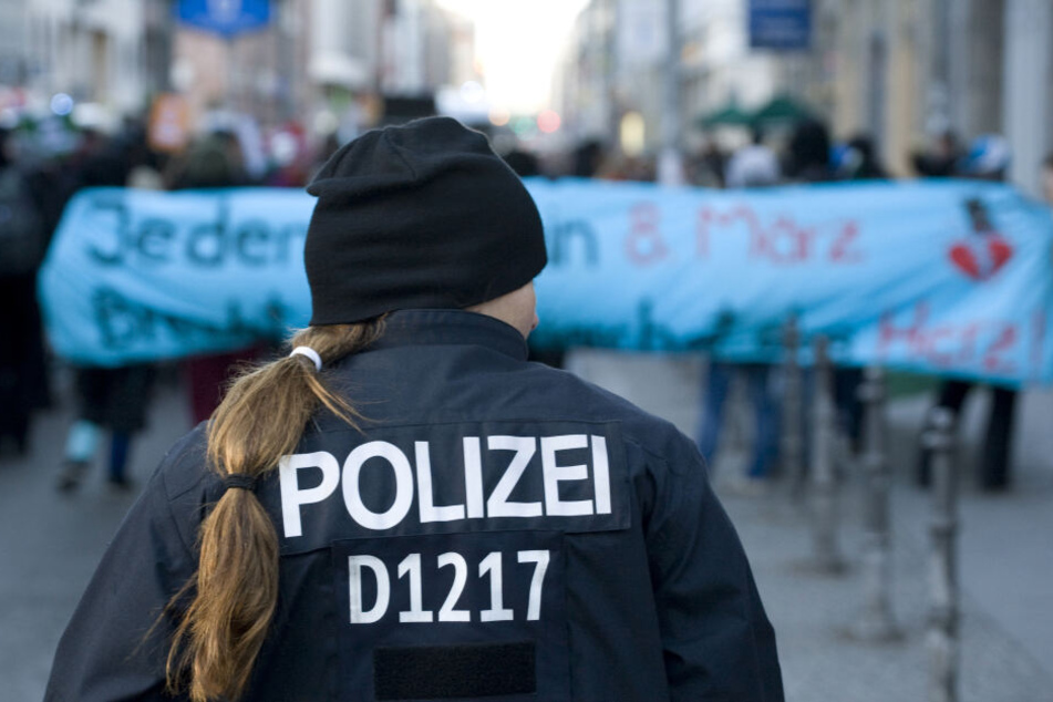 Eine Polizistin beobachtet am 08.03.2012 in Berlin im Bezirk Mitte Teilnehmerinnen einer Demonstration linker Frauengruppen zum Weltfrauentag.