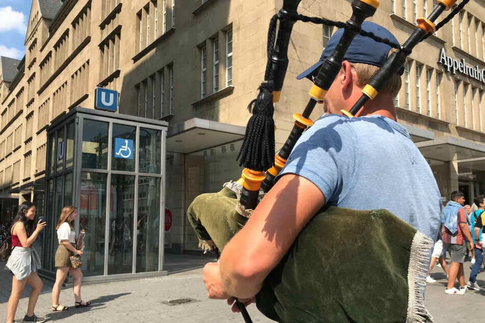 John (40) spielt am Neumarkt schottische Folksongs auf seinem Dudelsack.