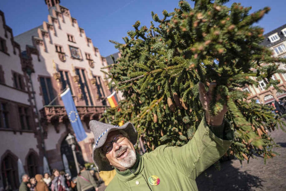 Eberhard Eisentraud von der Theatergruppe "Peter von Orb" steht als Spessarträuber verkleidet neben dem diesjährigen Frankfurter Weihnachtsbaum.