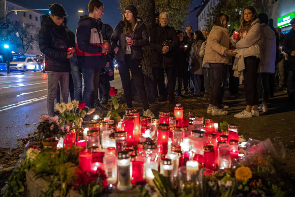 Menschen stehen an aufgestellten Kerzen bei der Mahnwache für den bei dem Raserunfall getöteten 14-Jährigen an der Fürstenrieder Straße.