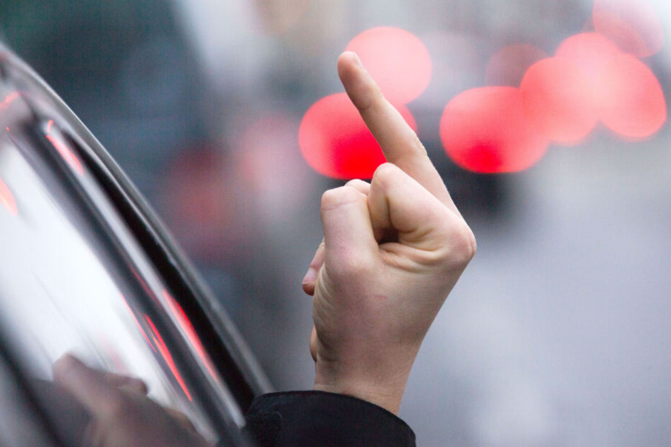 Ein Rowdy auf vier Rädern zeigt den "Stinkefinger" aus seinem Auto (Symbolbild).