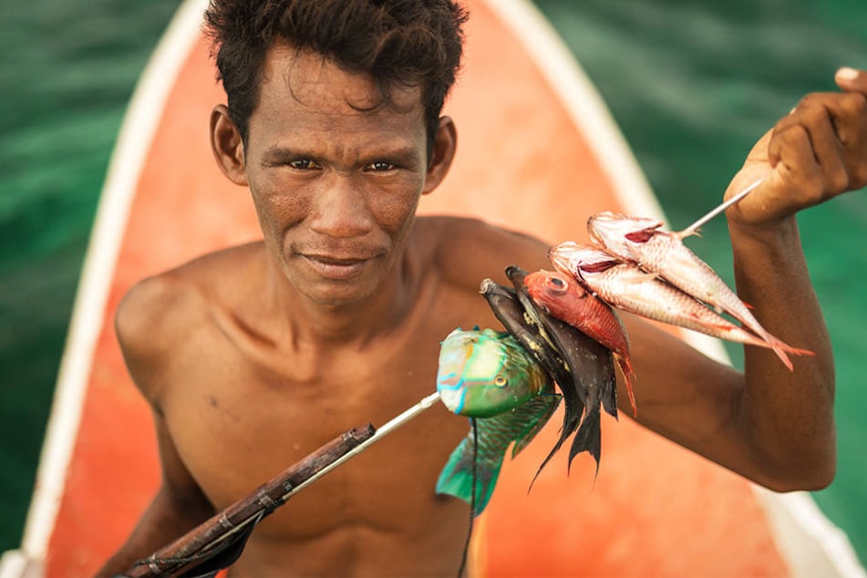 Ein Bajau, Seenomade, der in den Gewässern vor Indonesien lebt, präsentiert seinen Fang. Ihre Existenz wird durch die extreme Überfischung bedroht.