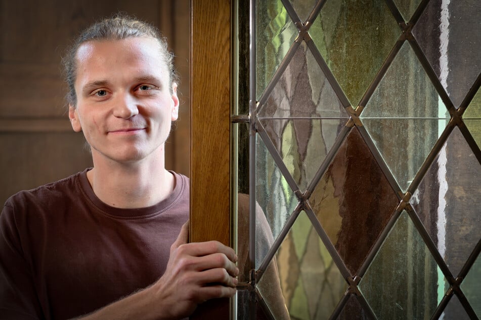 Bautischler Valentin Bube (25) steht an einem der überarbeiteten Bleiglasfenster.