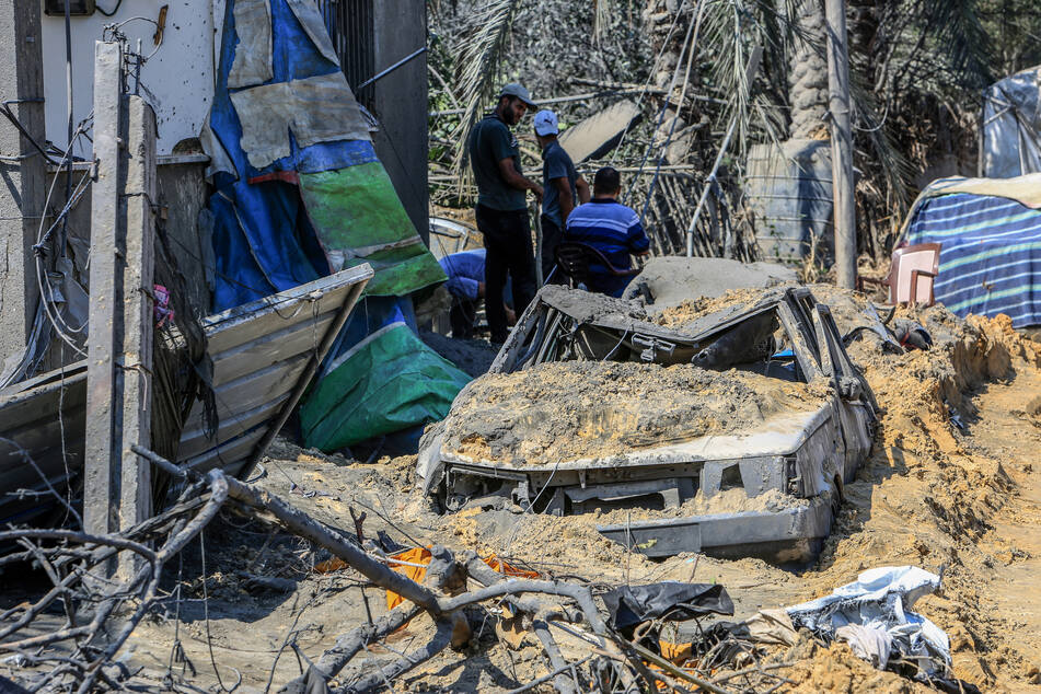 Vertriebene Palästinenser kehren in ihre zerstörten Zelte zurück, um ihre Habseligkeiten nach einem israelischen Bombenangriffs auf das Lager Al-Mawasi zu begutachten.