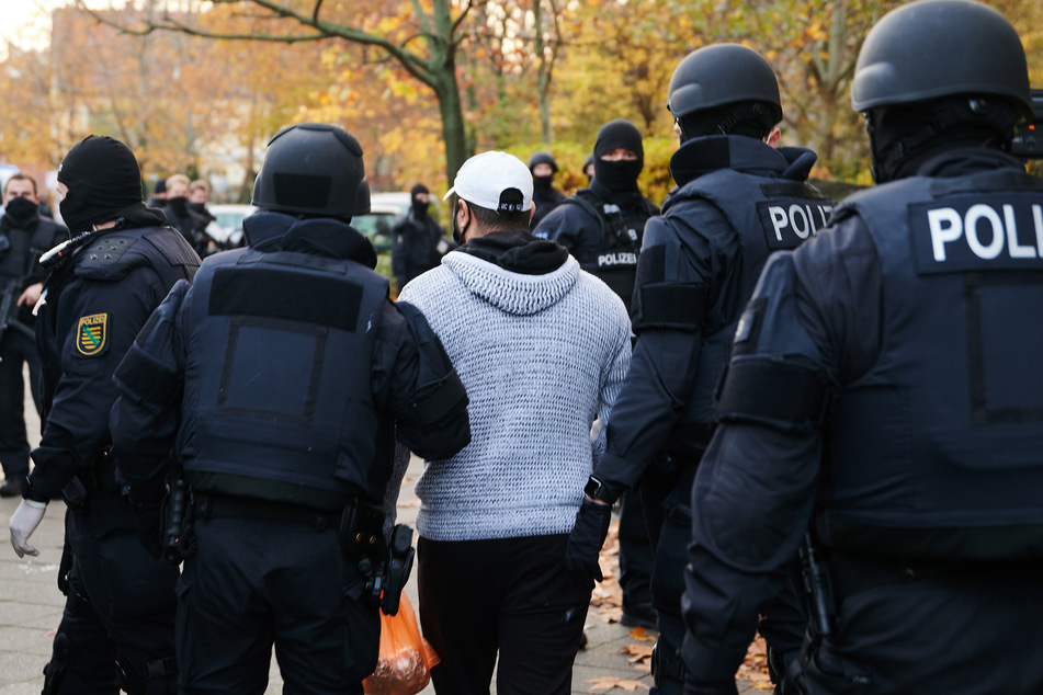 Beamte der Polizei bringen bei einem Einsatz eine Person zur Identitätsprüfung.