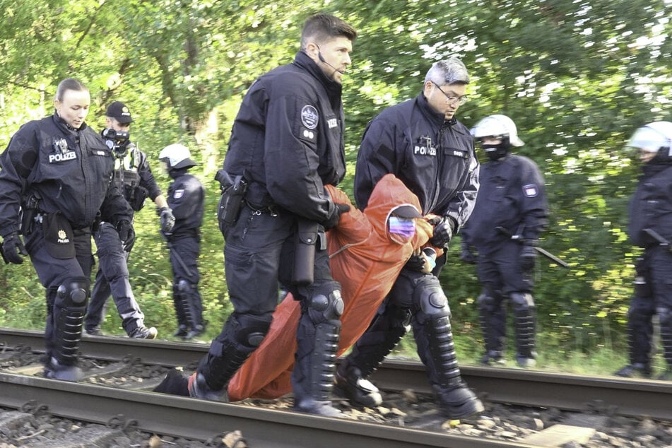 Die Polizei hat den Protest mittlerweile aufgelöst und die Aktivisten von den Gleisen geschleppt.