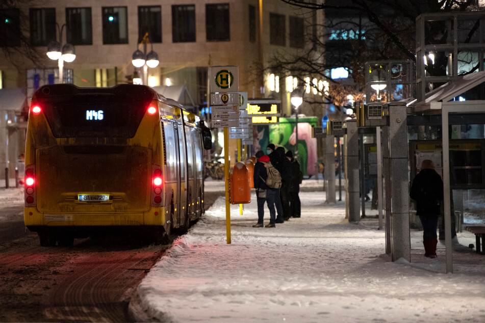 Berlin: Reisende stehen am frühen Morgen am Bahnhof Zoo an einer Bushaltestelle vor einem Bus.