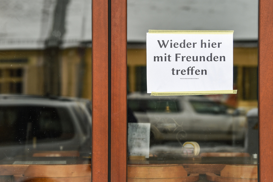 Am Fenster einer geschlossenen Bar in Friedrichshagen hängt ein Schild mit der Aufschrift "Wieder hier mit Freunden treffen".